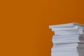 Stack of paper sheets on orange background. Space for text Royalty Free Stock Photo