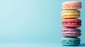 Stack of pastel-colored French macarons against a light blue background, showcasing variety of flavors and textures with Royalty Free Stock Photo