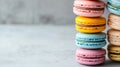 A stack of pastel-colored French macarons including pink, yellow, and blue varieties, arranged on a light background with ample Royalty Free Stock Photo