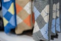 Stack of patterned socks featuring classic argyle design in multiple colors folded uniformly on a retail display