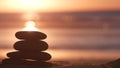 Stack of pebble stones, sandy ocean beach, sunset sky. Rock balancing by water. Royalty Free Stock Photo