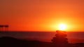 Stack of pebble stones, sandy ocean beach, sunset sky. Rock balancing by water. Royalty Free Stock Photo