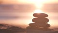 Stack of pebble stones, sandy ocean beach, sunset sky. Rock balancing by water. Royalty Free Stock Photo