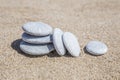 Stack of pebble stones unbalanced on a sandy beach