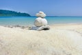 Stack of pebbles on white sand at the beach