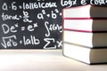 Stack and pile of books in front of a blackboard in school. Royalty Free Stock Photo