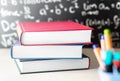 Stack and pile of books on table in front of a blackboard Royalty Free Stock Photo