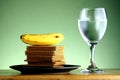 Stack or pile of crackers, a banana and a goblet of water