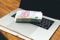 Stack pile of 500 100 200 Euro bank currency laptop Royalty Free Stock Photo