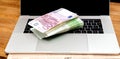 Stack pile of 500 100 200 Euro bank currency laptop Royalty Free Stock Photo