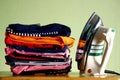 Stack or pile of folded shirts and an iron Royalty Free Stock Photo