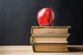 Stack Pile of Old Books Red Glossy Apple on Top. Learning Education Knowledge Concept. Blackboard Background. Classrom. Royalty Free Stock Photo