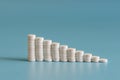 A stack of pills on a blue background. Growth graph made of stacked white pills - growing market and increasing demand for white p Royalty Free Stock Photo