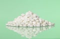Stack of pills towards green background Royalty Free Stock Photo