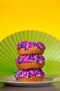 A stack of 3 pink sprinkle donuts, art nouveau style background