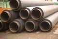 Stack of pipes for underground heating mains lying in city street Royalty Free Stock Photo