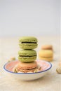 Stack of pistachio nut and chocolate flavor macaroons on a marble table