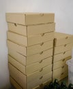 Stack of plain craft pizza boxes against white wall Royalty Free Stock Photo