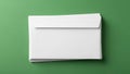A stack of plain white envelopes lies on a solid green surface Royalty Free Stock Photo