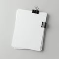 A stack of plain white papers held together by a large black binder clip is placed Royalty Free Stock Photo