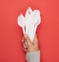 Stack of plastic forks and spoons on red background Royalty Free Stock Photo