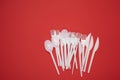 Stack of plastic forks and spoons on red background, top view Royalty Free Stock Photo