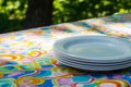 stack of plastic plates on a picnic table with a colorful tablecloth Royalty Free Stock Photo