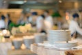 Stack of plate on counter and blurred background. Groups of Chef preparation counter of food in the open kitchen, International