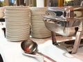 Stack of plates and chafing dish on buffet table in banquet setting Royalty Free Stock Photo