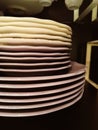 stack of plates on a dark background. Big stack of different colors mugs and plate Royalty Free Stock Photo