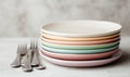 A stack of plates with forks and knives on a table Royalty Free Stock Photo
