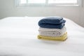 Stack of plush hotel clean soft,Blue,Yellow towel on bed decoration in bedroom Royalty Free Stock Photo