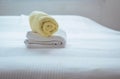 Stack of plush hotel clean soft towels White,Blue,Yellow towel on bed decoration in bedroom