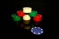 Stack of poker chips with a blue chip in front and reflections isolated on black Royalty Free Stock Photo