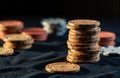 Stack of poker chips on a dark surface with scattered chips in the background Royalty Free Stock Photo