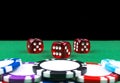 Stack of Poker chips on a green gaming poker table with poker dice at the casino . Playing a game with dice. Casino dice Concept Royalty Free Stock Photo