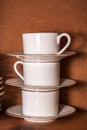 Stack of porcelain coffee cups with gold rim on wooden background Royalty Free Stock Photo
