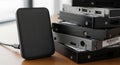 A stack of portable external hard drives on a wooden surface Royalty Free Stock Photo