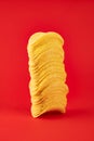 Stack of potato chips in bright red background. Minimalistic image of attention grabbing fast food in vivid colors