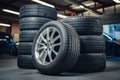 Stack of pristine car tires in workshop, illuminated by overhead lights Royalty Free Stock Photo