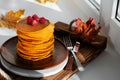 A stack of pumpkin pancakes with raspberries. Healthy vegetarian food