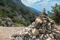 Stack pyramide of stones on top of mountain on background of mountains covered with forests. Croatia, Bol island