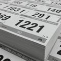 Stack of race bibs with bold numbers and text, featuring a large number \
