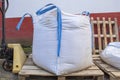 Stack of raffia large sand sack over Hand Pallet Jack Hydraulic Welding Pump Royalty Free Stock Photo