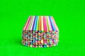 Stack Rainbow colored paper baking cups for muffins and cupcakes on a green background minimal creative concept. Space