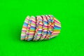 Stack Rainbow colored paper baking cups for muffins and cupcakes on a green background minimal creative concept. Space