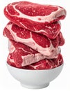 Stack of Raw Red Marbled Beef Steaks in a White Bowl on White Background Royalty Free Stock Photo