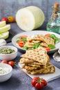 A stack of ready-to-eat zucchini waffles and basil on baking paper on the table. Vegetable dietary vegetarian food. Vertical view