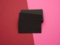 Stack of rectangular black paper blank business cards on pink red background Royalty Free Stock Photo