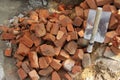 Stack of red clay Bricks and sand Shovel on filed construction site